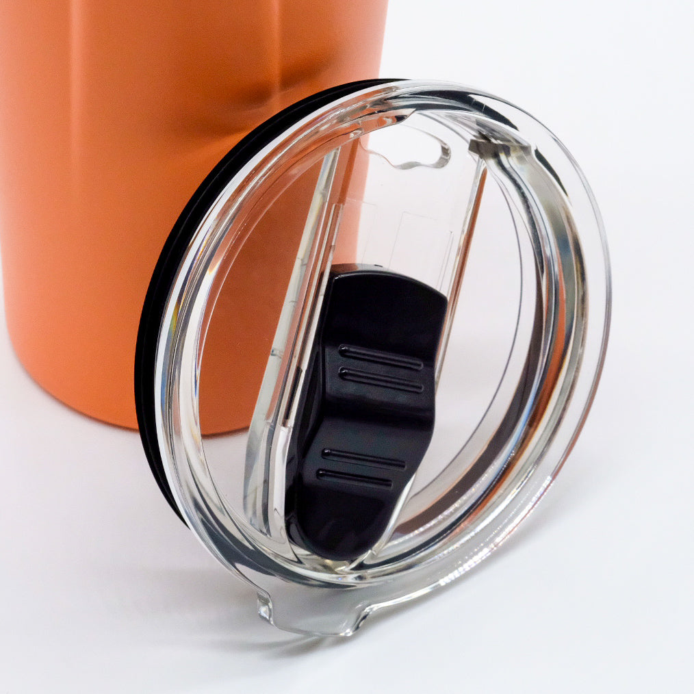 Couvercle transparent amovible avec ouverture coulissante, placé devant un bouteille isotherme orange doTERRA.