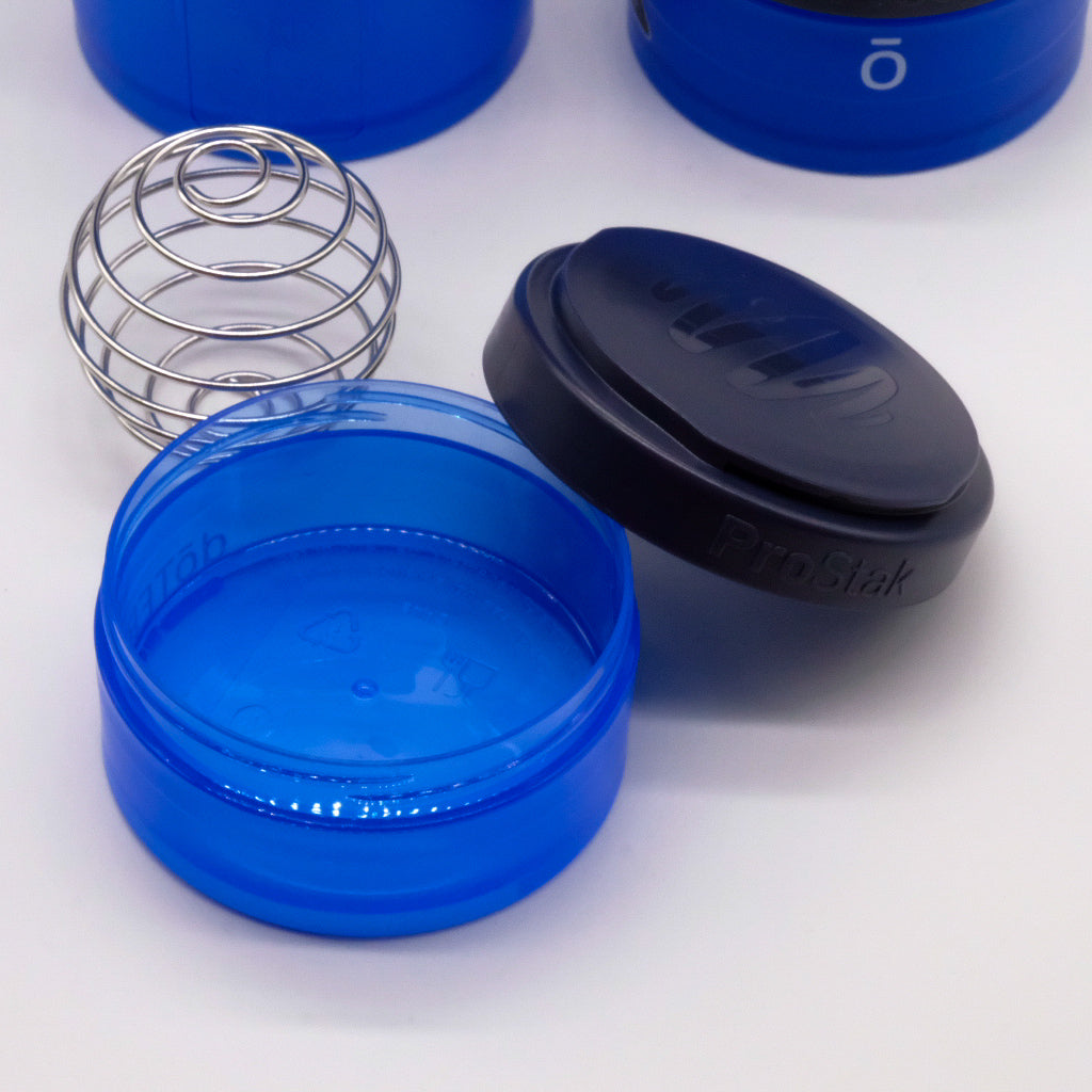 Gros plan sur le compartiment bleu d’un shaker doTERRA, avec couvercle noir et fouet bille en métal.