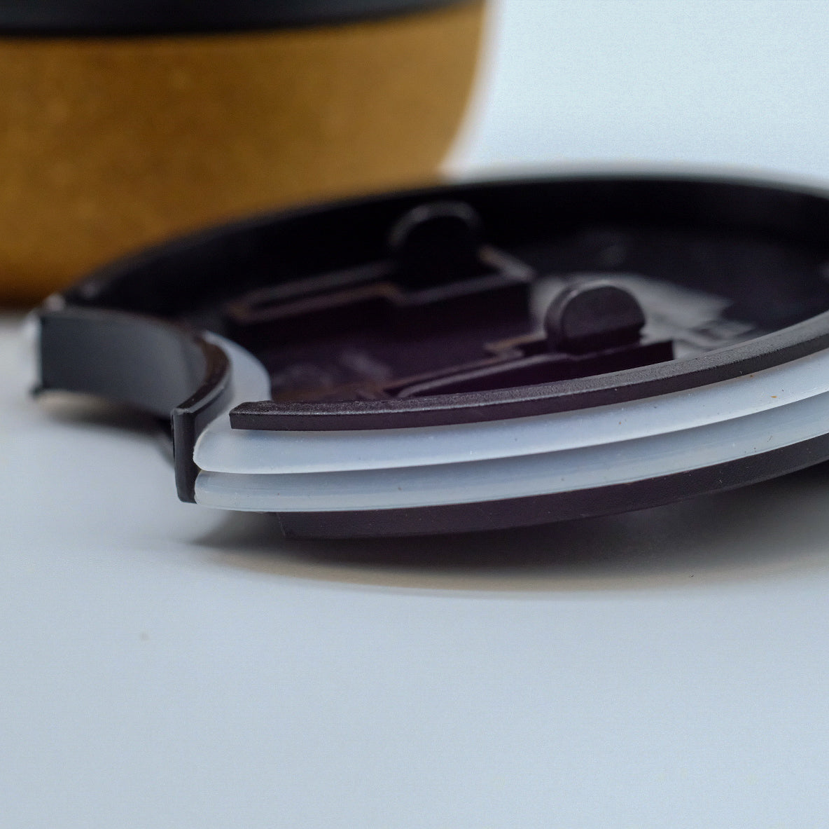 Gros plan sur le couvercle d’une tasse doTERRA, avec la base en liège visible en arrière-plan.