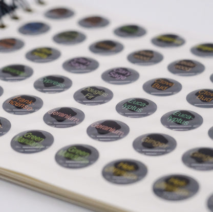 Gros plan sur une page du livret de collants en époxy doTERRA, montrant plusieurs autocollants ronds pour identifier les bouchons d’huiles essentielles.