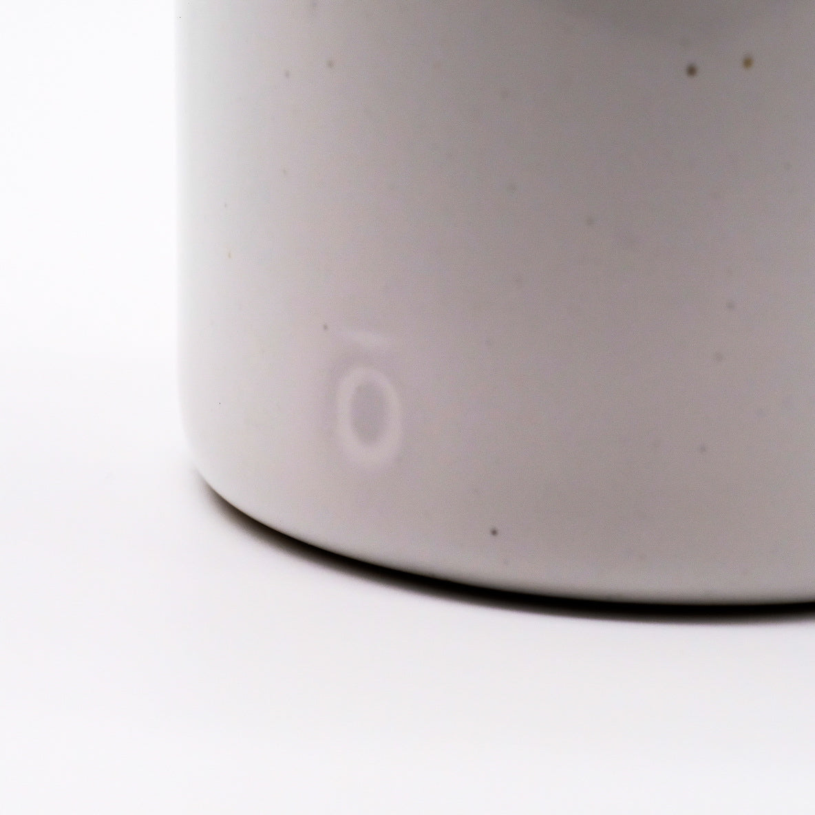 Gros plan sur le logo discret du Lava Basin 2-en-1 de doTERRA en céramique blanche.