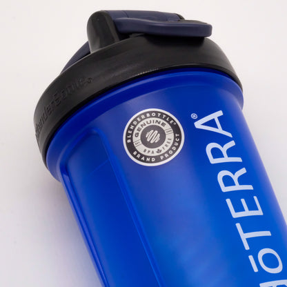 Gros plan sur un shaker bleu doTERRA avec couvercle noir rabattable et logo imprimé sur le côté.