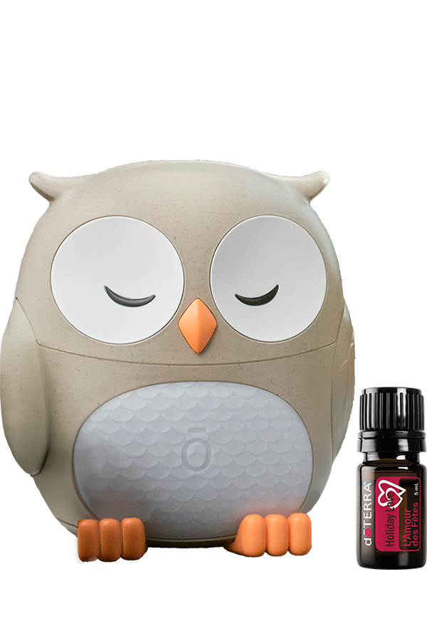 Diffuseur hibou doTERRA beige et blanc avec la synergie Holiday Love 5 ml placée à côté.