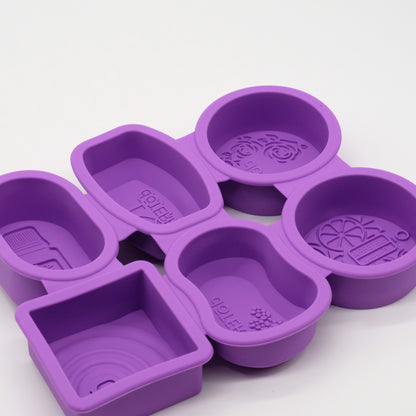 Ensemble de moules en silicone violets doTERRA avec formes variées, incluant des moules ronds, carrés et rectangulaires avec motifs embossés.