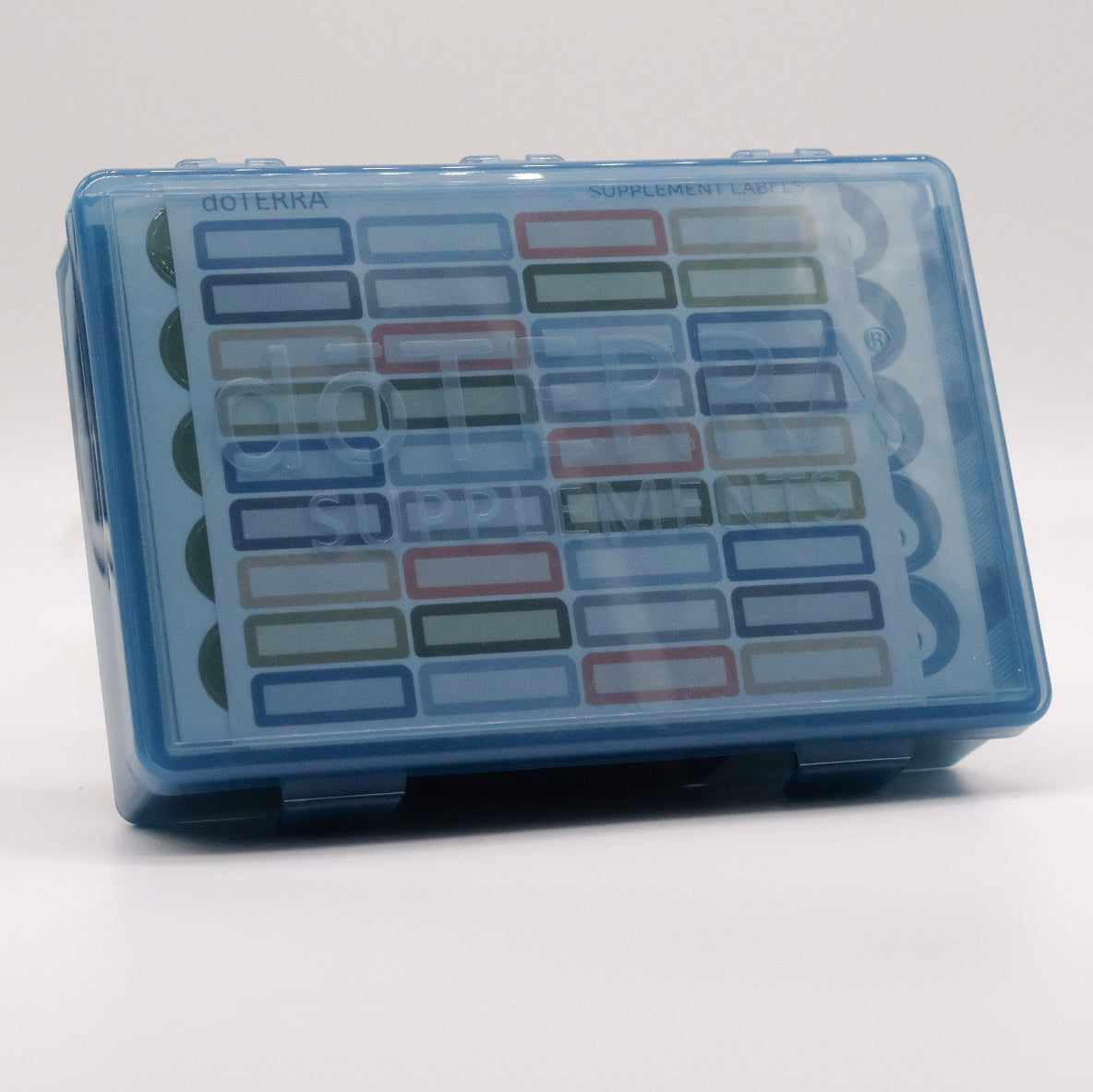 Grand pilulier bleu translucide doTERRA pour suppléments, avec feuille d’étiquettes multicolores visible à l’intérieur.