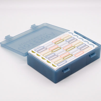 Grand pilulier bleu translucide doTERRA ouvert, avec feuilles d’autocollants colorés rangées à l’intérieur.