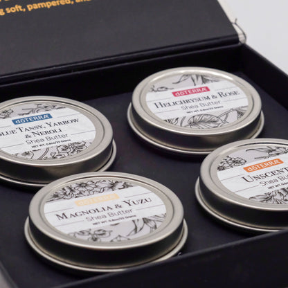 Gros plan sur quatre baumes de la collection beurre de karité doTERRA dans leur coffret : Blue Tansy, Yarrow & Neroli, Helichrysum & Rose, Magnolia & Yuzu, et une version sans parfum.