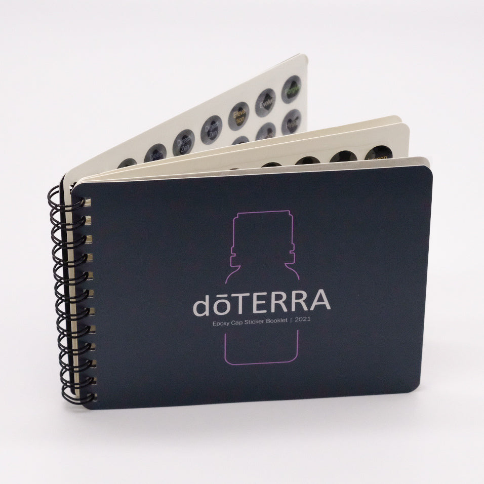 Livret de collants doTERRA pour bouchons d’huiles essentielles, avec reliure spirale et pages de pastilles visibles.