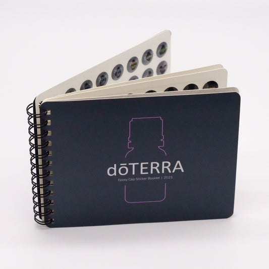 Livret de collants doTERRA pour bouchons d’huiles essentielles, avec reliure spirale et pages de pastilles visibles.