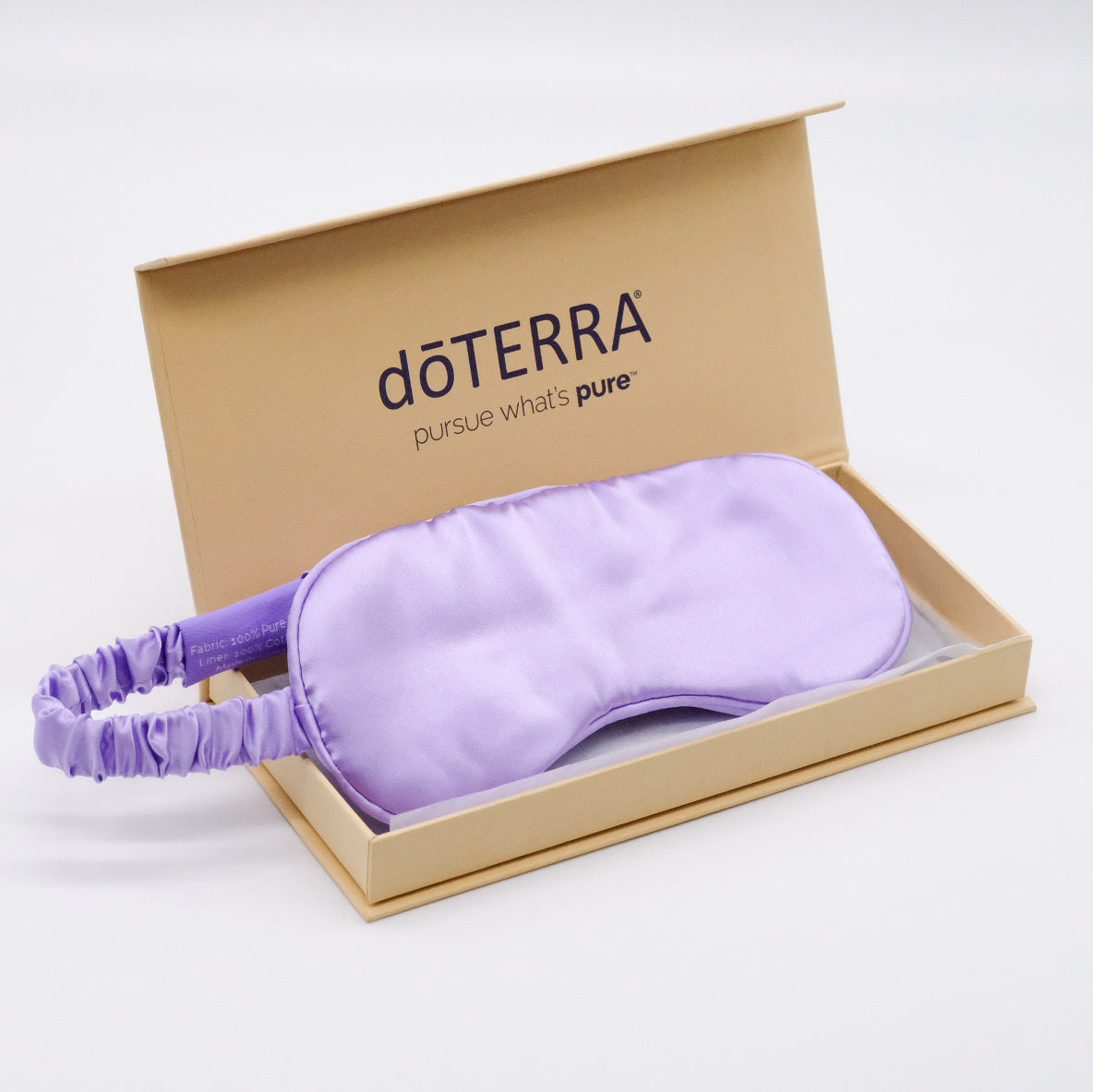 Masque en soie de mûrier doTERRA de couleur lilas, présenté dans une boîte beige ouverte.