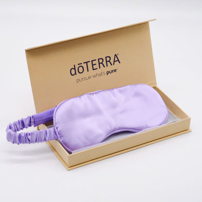 Masque en soie de mûrier doTERRA de couleur lilas, présenté dans une boîte beige ouverte.