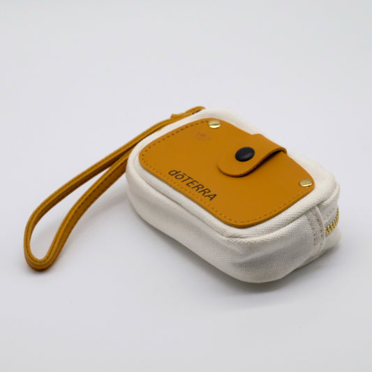 Mini étui blanc doTERRA avec rabat camel, fermeture éclair dorée et attache-poignet assortie.