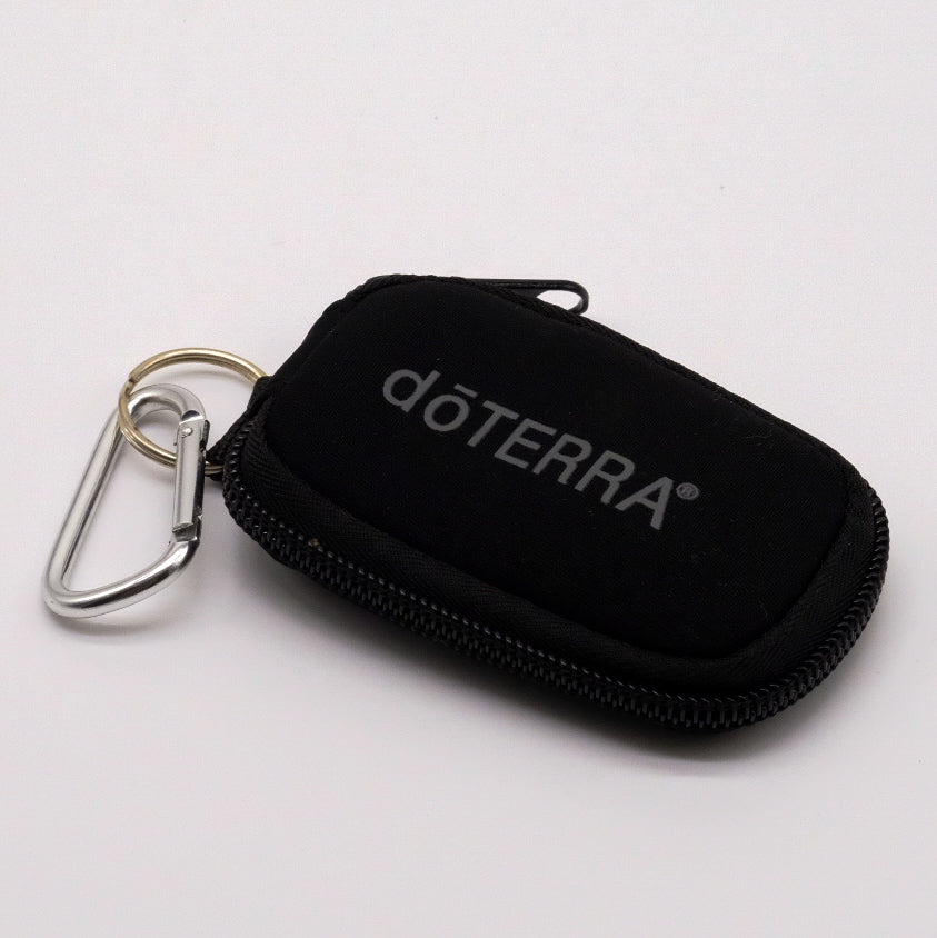 Mini étui noir doTERRA avec fermeture éclair et mousqueton métallique, présenté fermé sur fond blanc.