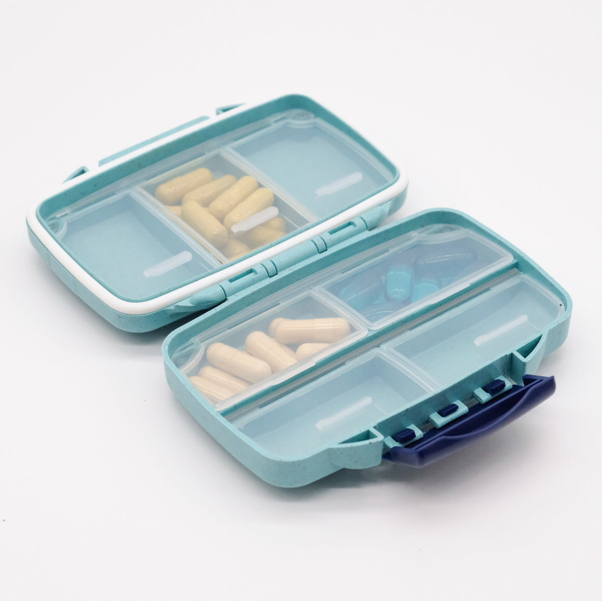 Pilulier portatif turquoise doTERRA ouvert, avec compartiments translucides contenant des gélules beiges et bleues.