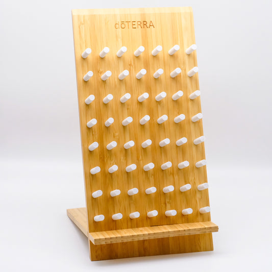 Présentoir en bambou doTERRA avec plusieurs chevilles blanches pour suspendre ou exposer de petits articles, présenté sur fond blanc.
