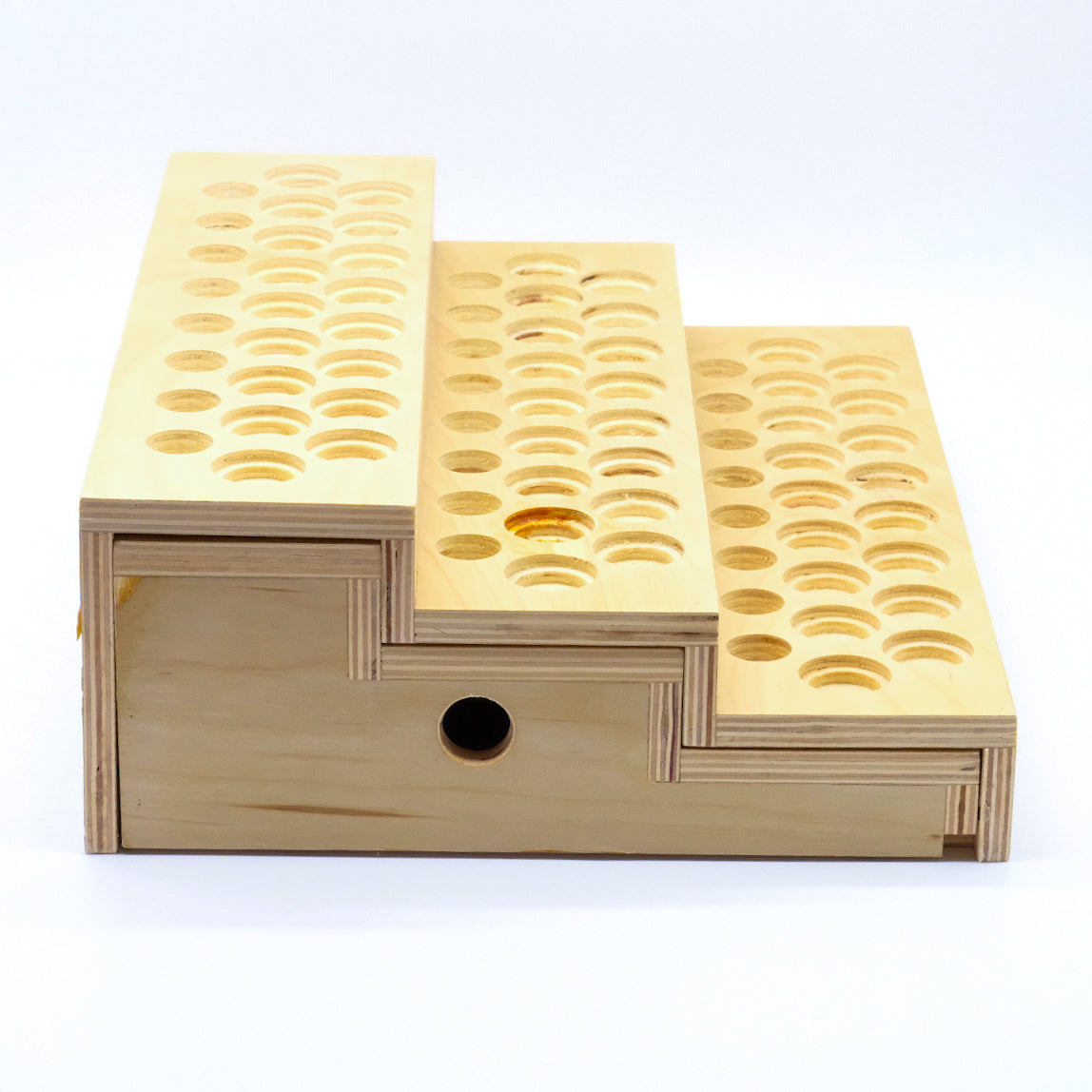 Présentoir en bois à 3 niveaux avec tiroir central et multiples emplacements pour bouteilles d’huiles essentielles.