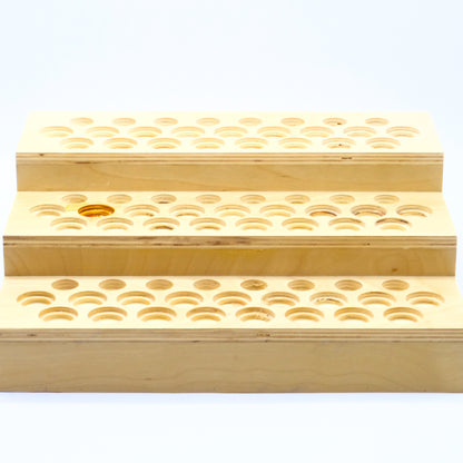 Présentoir en bois à 3 niveaux avec multiples emplacements ronds pour bouteilles d’huiles essentielles.