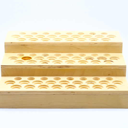 Présentoir en bois à 3 niveaux avec multiples emplacements ronds pour bouteilles d’huiles essentielles.
