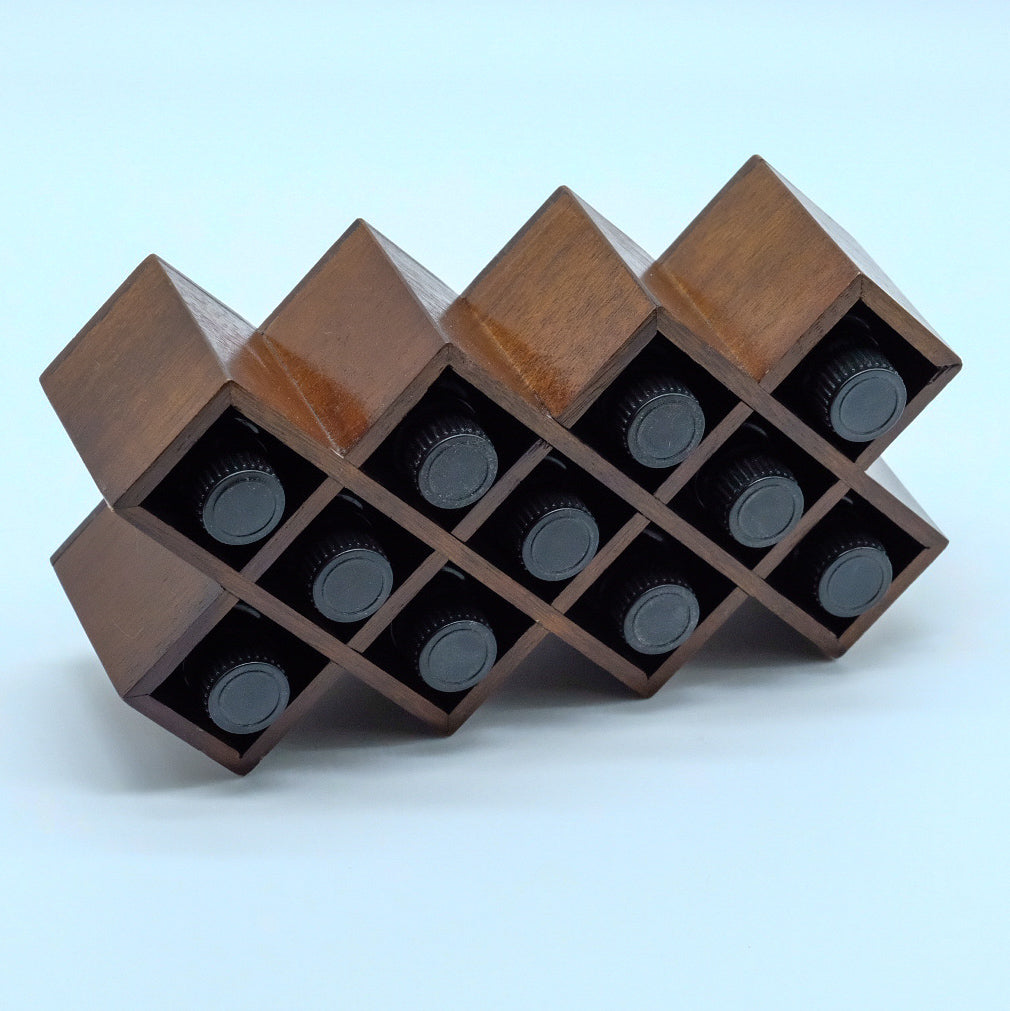 Présentoir en bois foncé, avec compartiments rectangulaires remplis de bouteilles d’huiles essentielles.