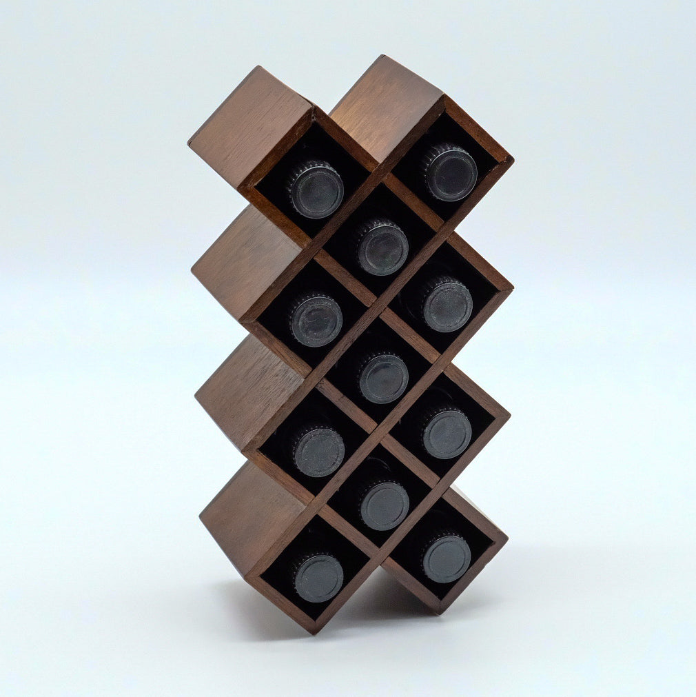 Présentoir en bois foncé, disposé à la verticale, avec plusieurs compartiments rectangulaires contenant des bouteilles d’huiles essentielles.