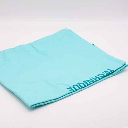 Robe Réutilisable AromaTouch pliée, en tissu bleu pâle, avec le mot « TECHNIQUE » visible dans un coin.