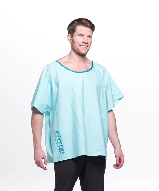 Homme portant la Robe Réutilisable AromaTouch, un vêtement ample bleu pâle à manches courtes, sur fond clair.