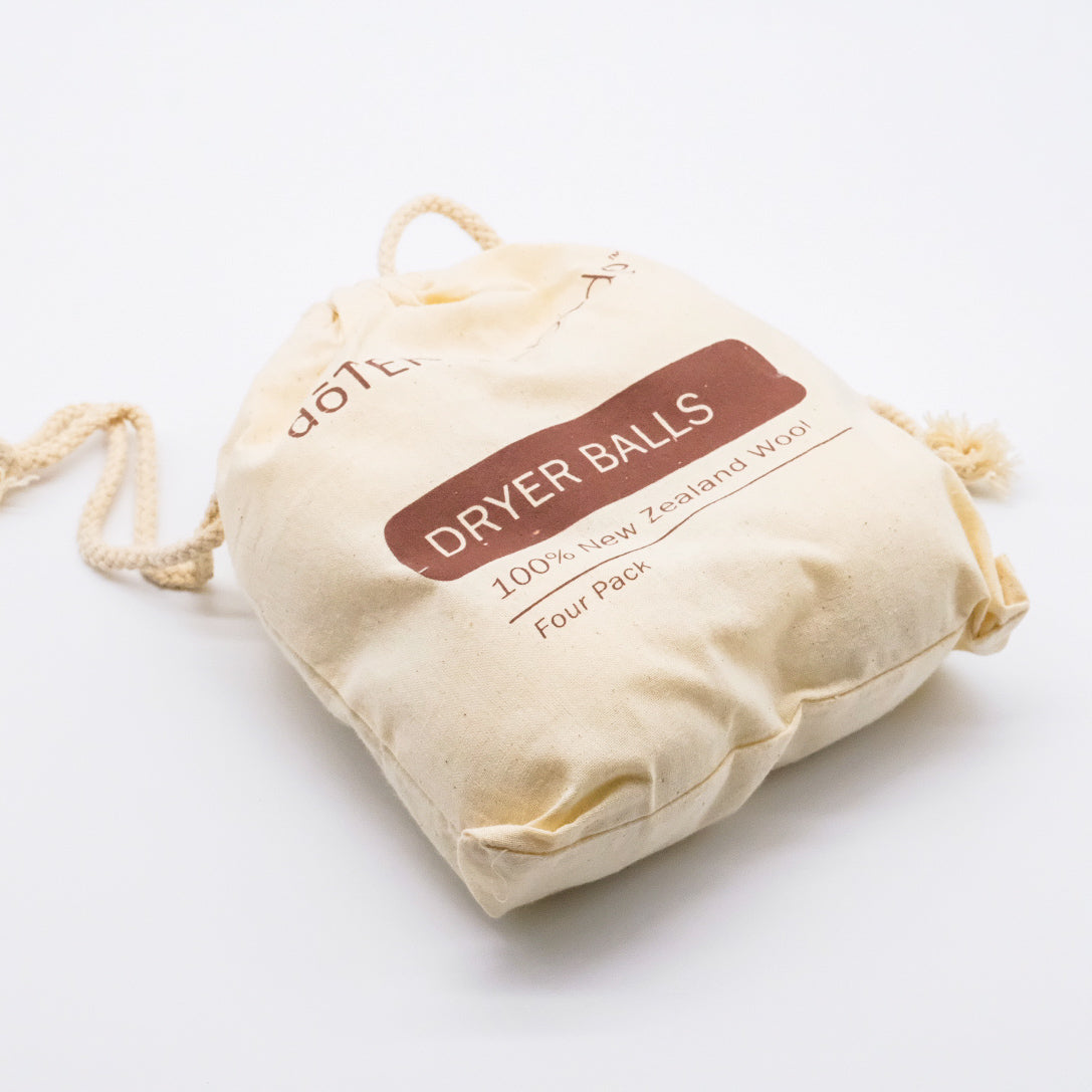 Sac en tissu doTERRA contenant un ensemble de 4 balles de sécheuse en laine de Nouvelle-Zélande, avec cordon de serrage.