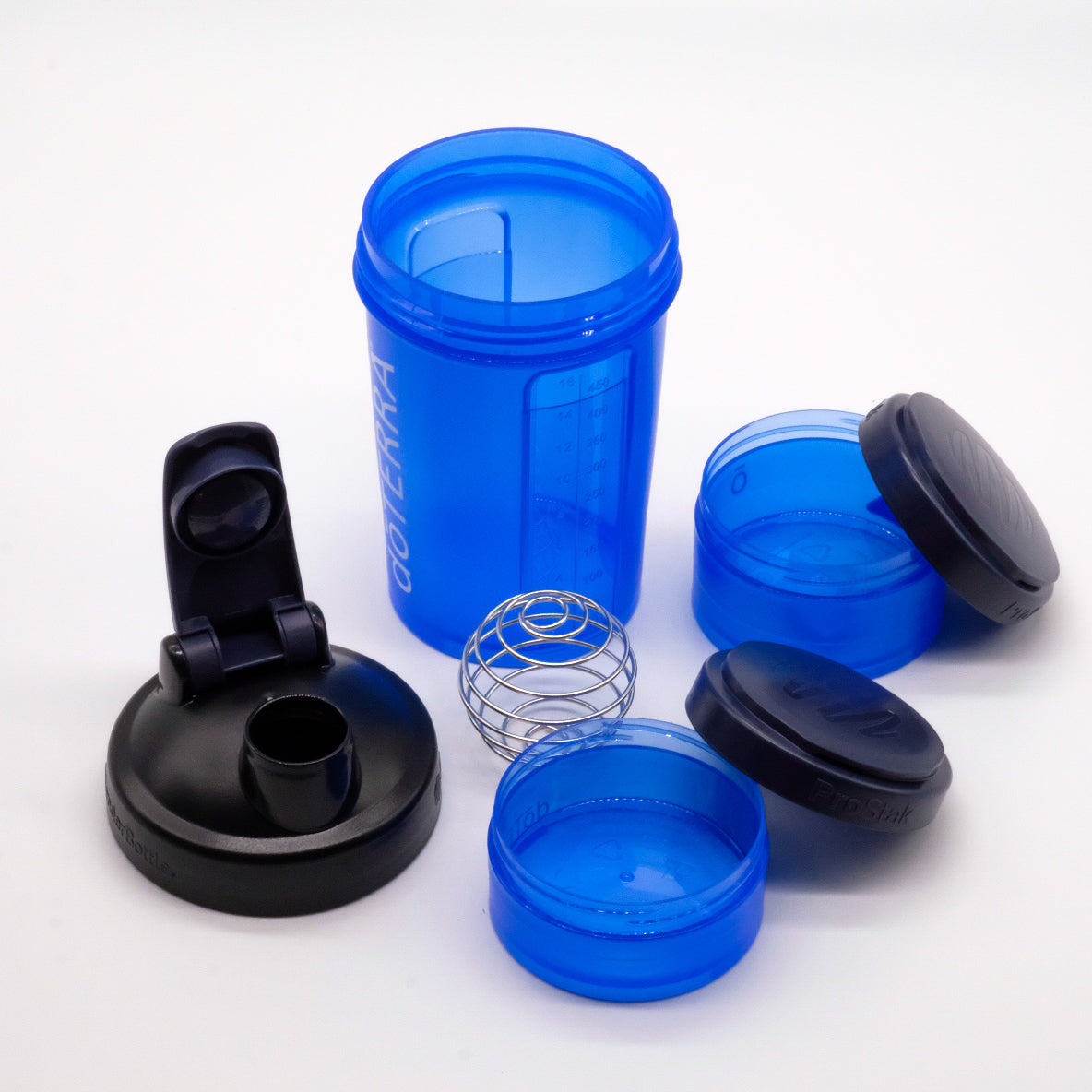 Shaker bleu doTERRA démonté avec couvercle noir, deux compartiments ProStak et fouet bille en métal.