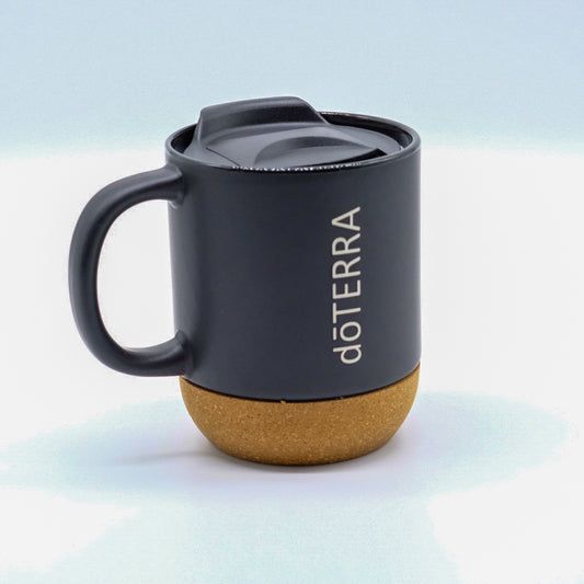Tasse noire doTERRA avec couvercle assorti, poignée latérale et base en liège, présentée sur fond clair.